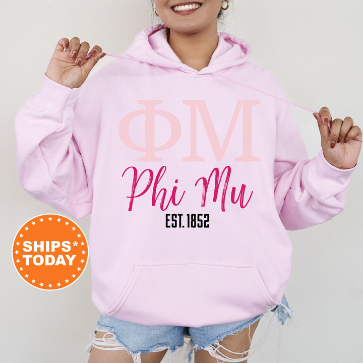 a woman wearing a pink phi mu hoodie