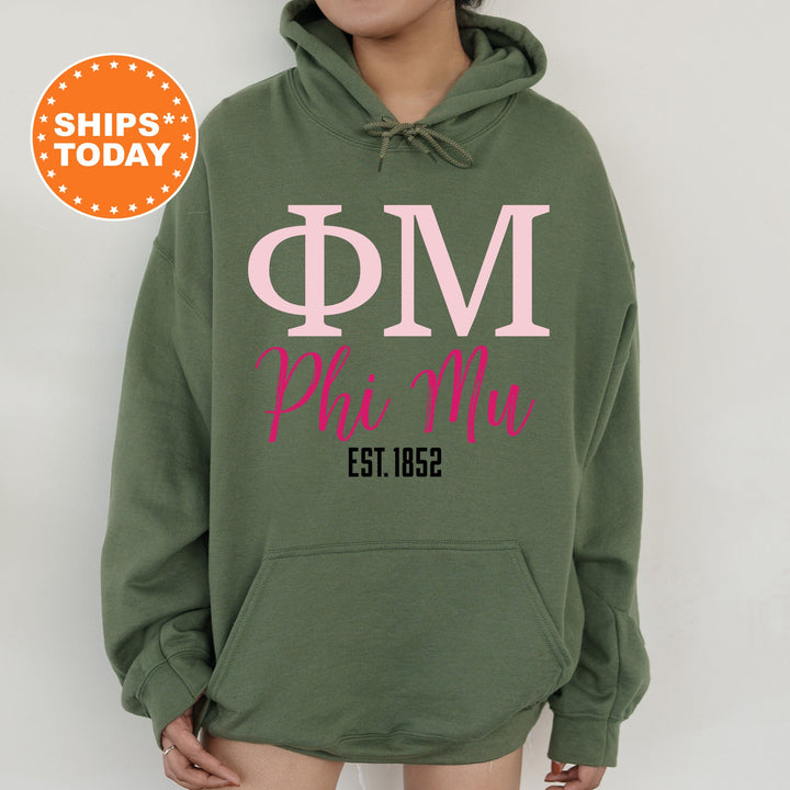 a woman wearing a green hoodie with pink letters