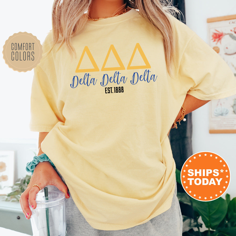 a woman wearing a yellow delta delta delta shirt