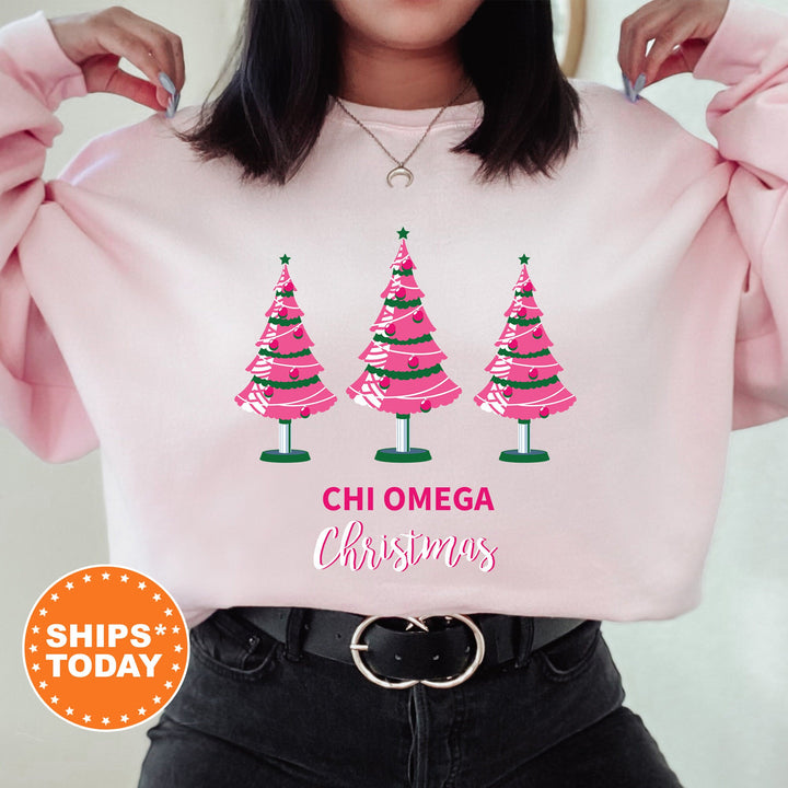 a woman wearing a pink sweatshirt with christmas trees on it