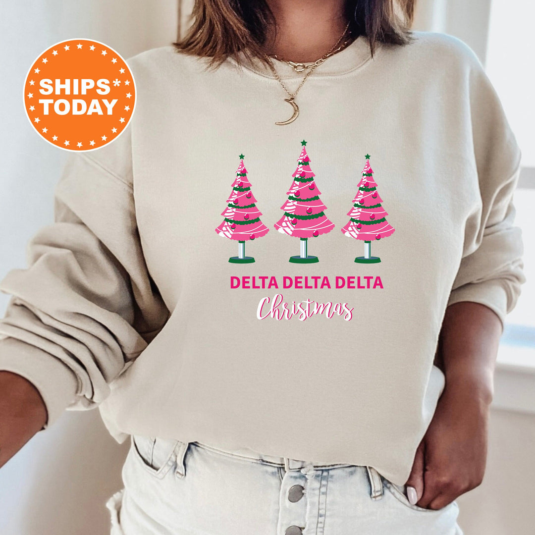 a woman wearing a sweatshirt that says delta delta delta christmas trees