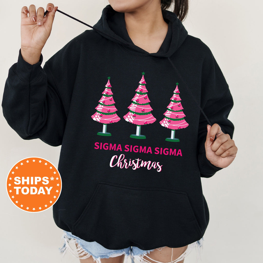 a woman wearing a black sweatshirt with pink christmas trees on it