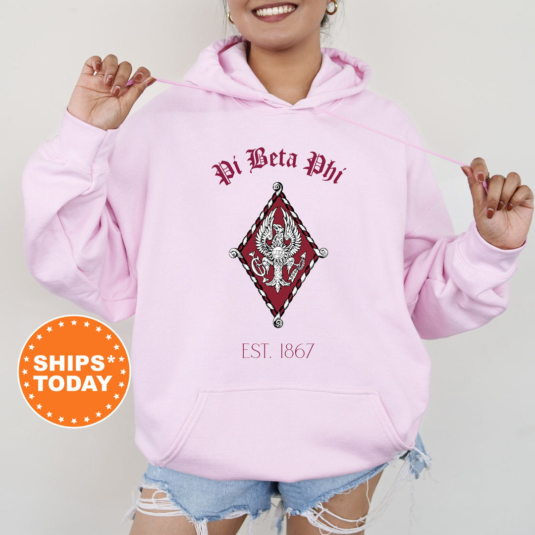 a woman wearing a pink hoodie with a diamond on it