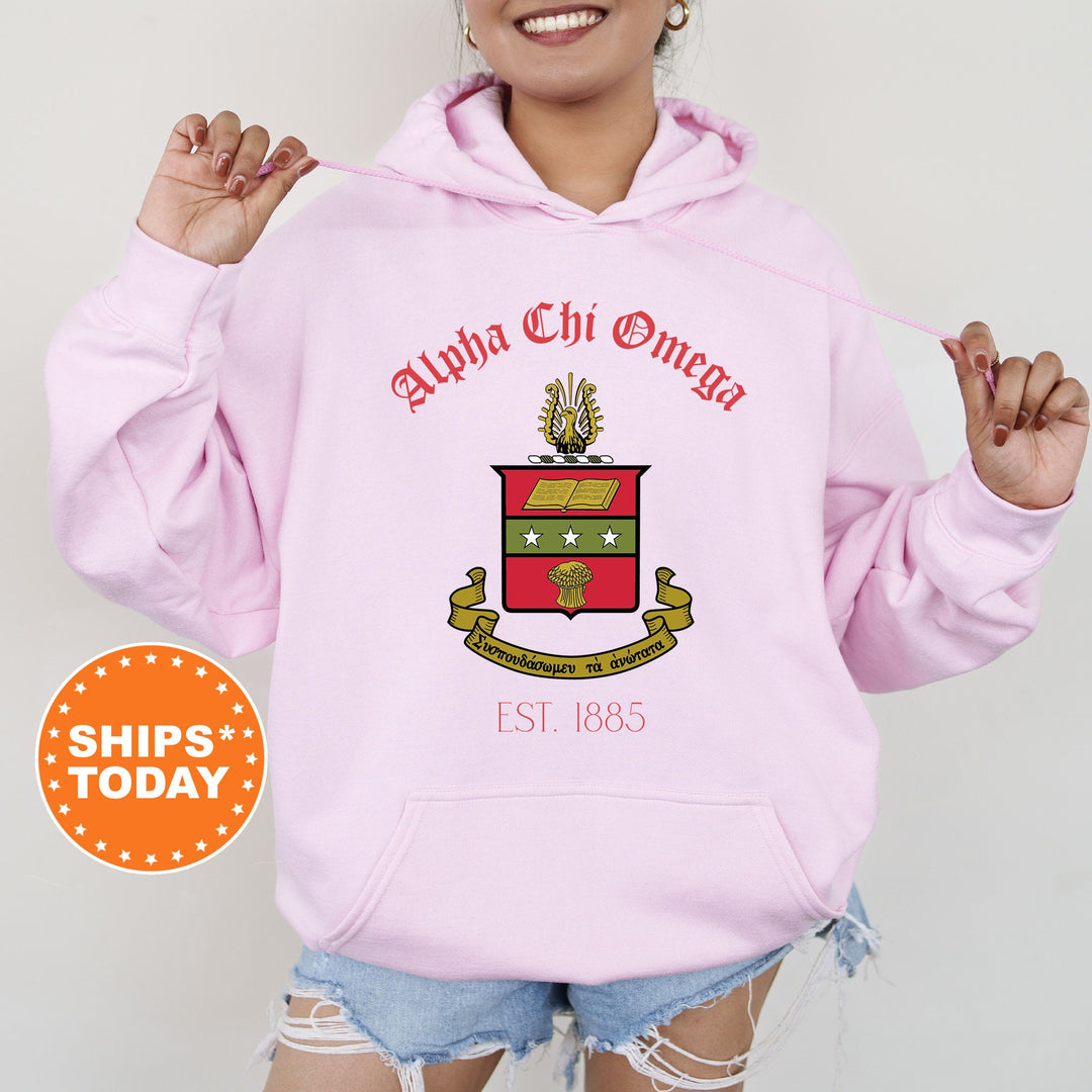 a woman wearing a pink hoodie with a coat of arms on it