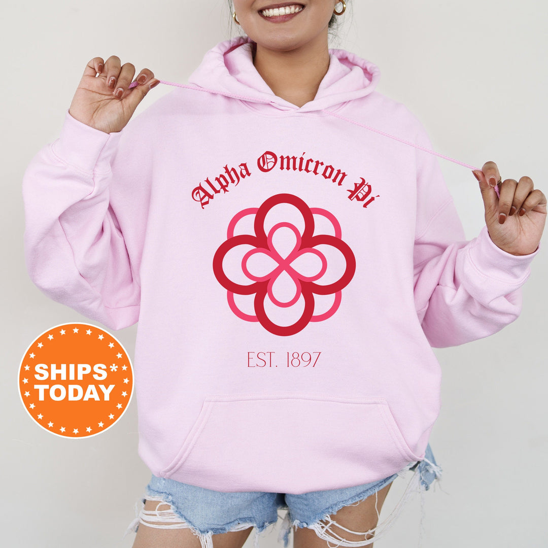 a woman wearing a pink hoodie with a flower on it