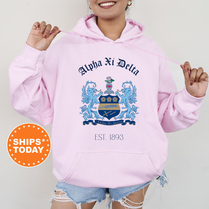 a woman wearing a pink hoodie with a coat of arms on it