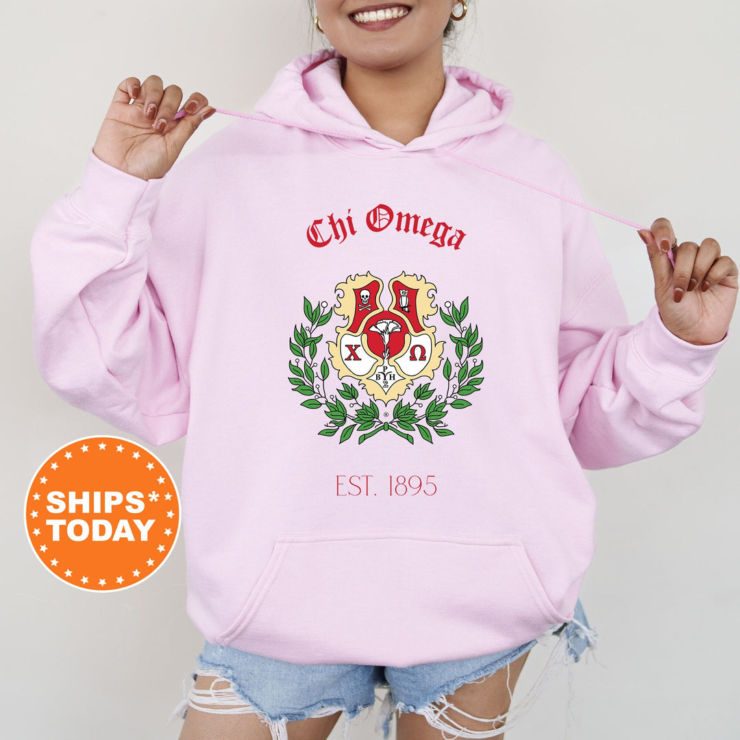 a woman wearing a pink hoodie with a crest on it
