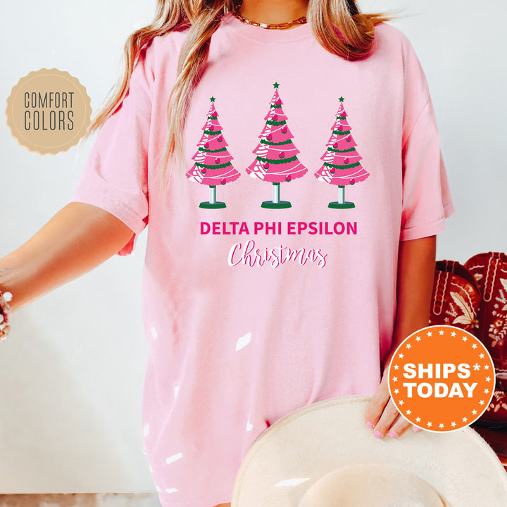 a woman wearing a pink shirt with three christmas trees on it