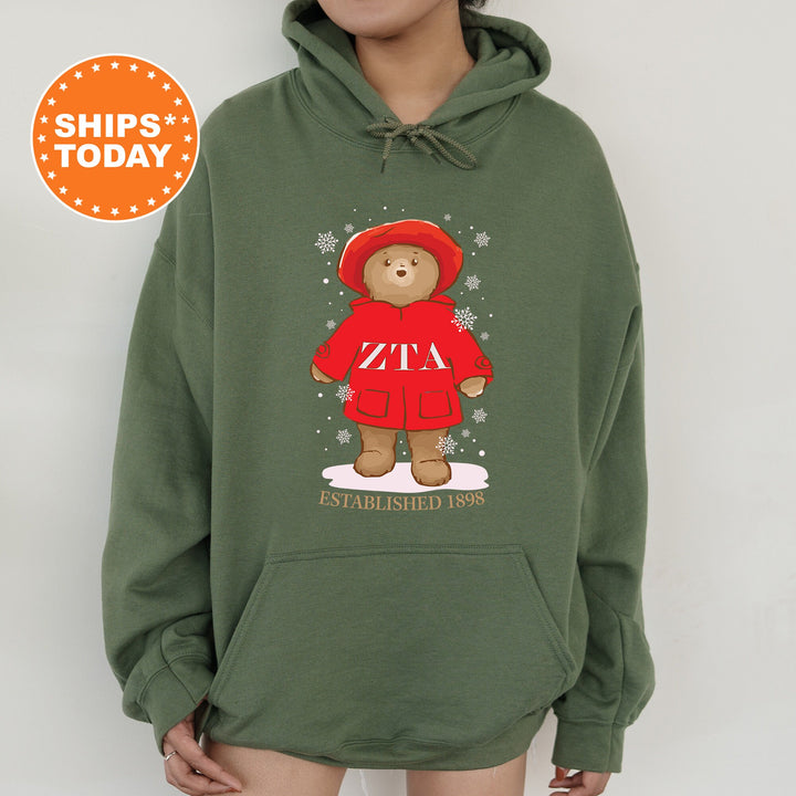 a woman wearing a green hoodie with a picture of a teddy bear on it