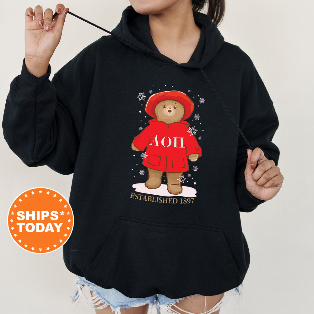 a woman wearing a black hoodie with a picture of a teddy bear on it