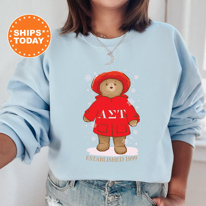 a woman wearing a blue sweatshirt with a picture of a teddy bear wearing a red