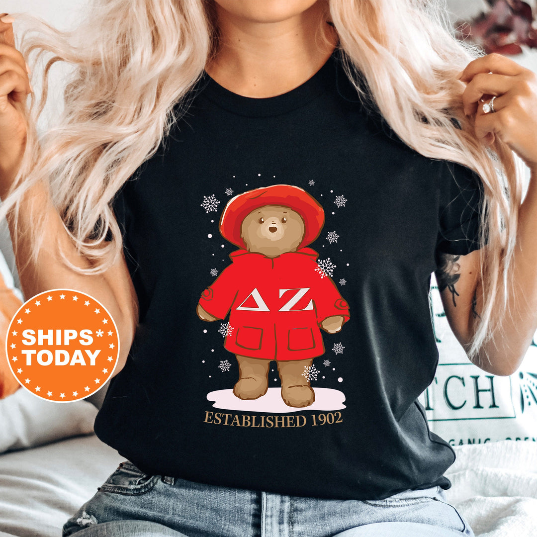 a woman wearing a black shirt with a red teddy bear on it