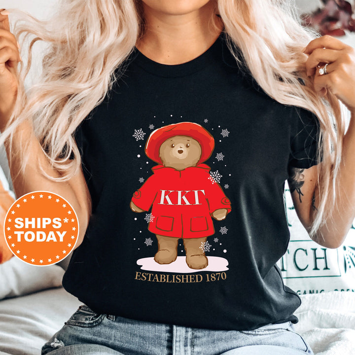a woman wearing a black t - shirt with a picture of a teddy bear wearing