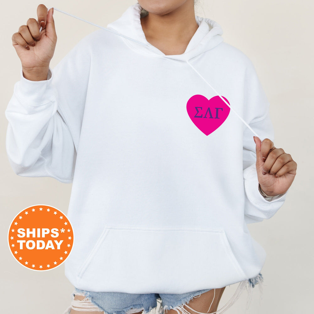 a woman wearing a white hoodie with a pink heart on it