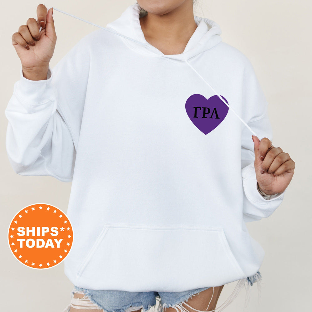 a woman wearing a white hoodie with a purple heart on it