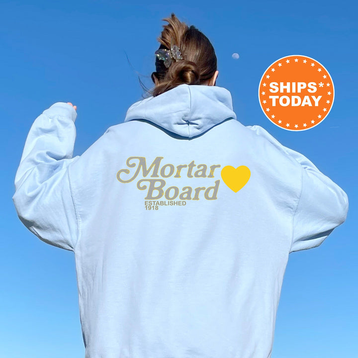 a woman wearing a white hoodie with the words mortar board on it
