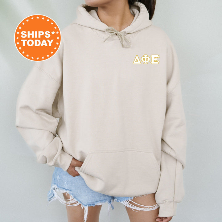 a woman wearing a beige hoodie with the letters aoe on it