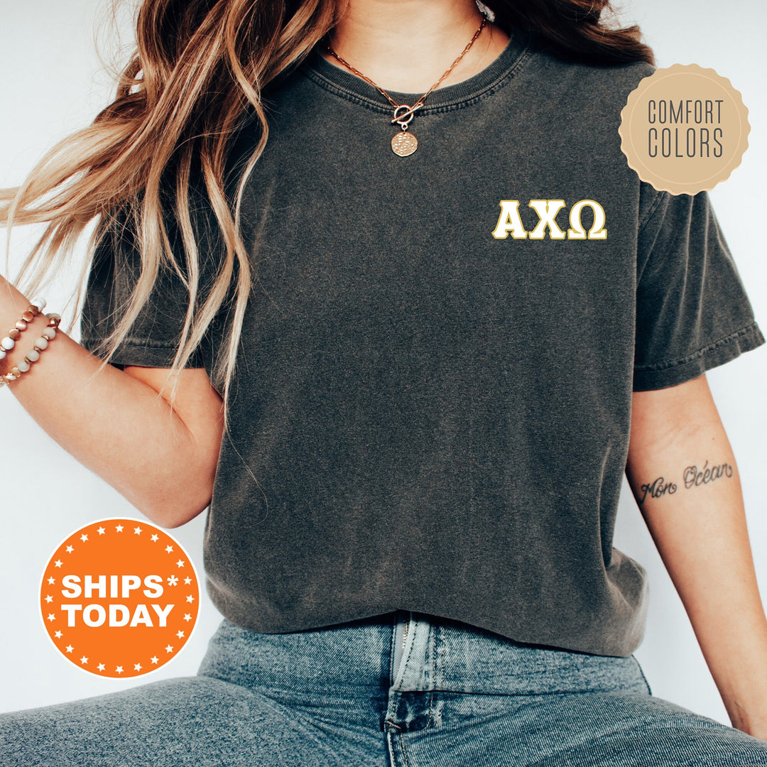 a woman wearing a black shirt with a gold axo on it