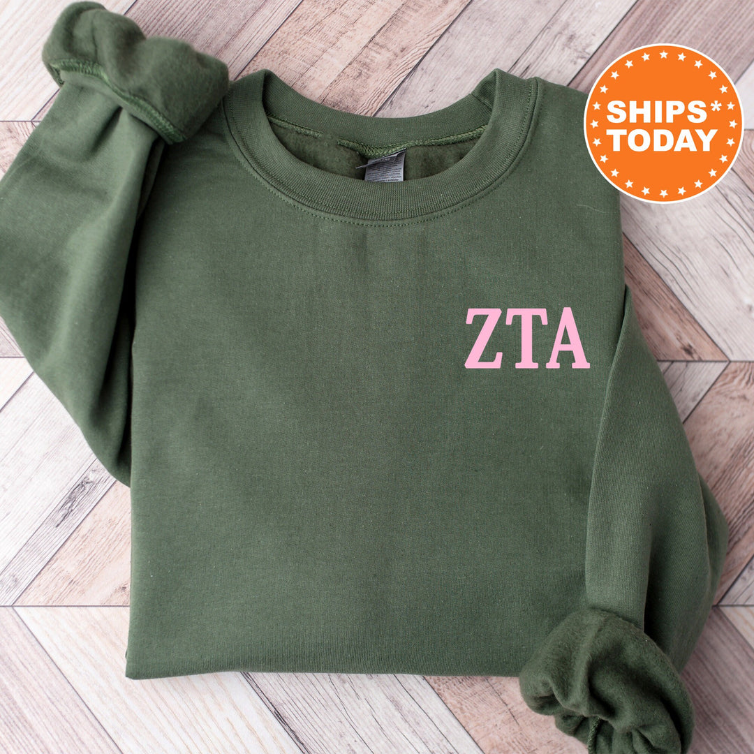 a green sweatshirt with a pink zta on it