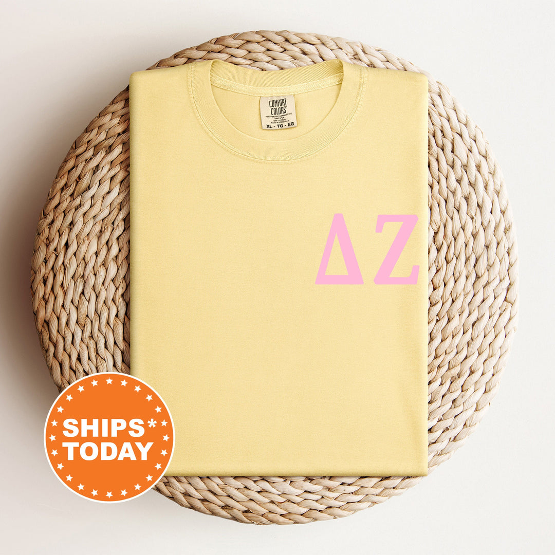 a yellow t - shirt with pink letters on it