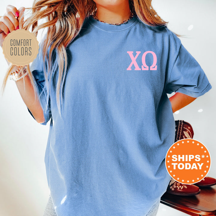 a woman wearing a blue shirt with a pink xo on it