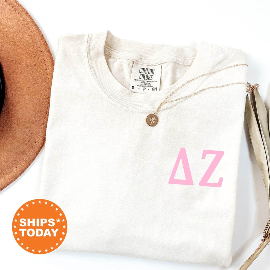 a hat and a white shirt with a pink letter on it