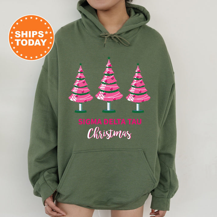 a woman wearing a green sweatshirt with pink trees on it