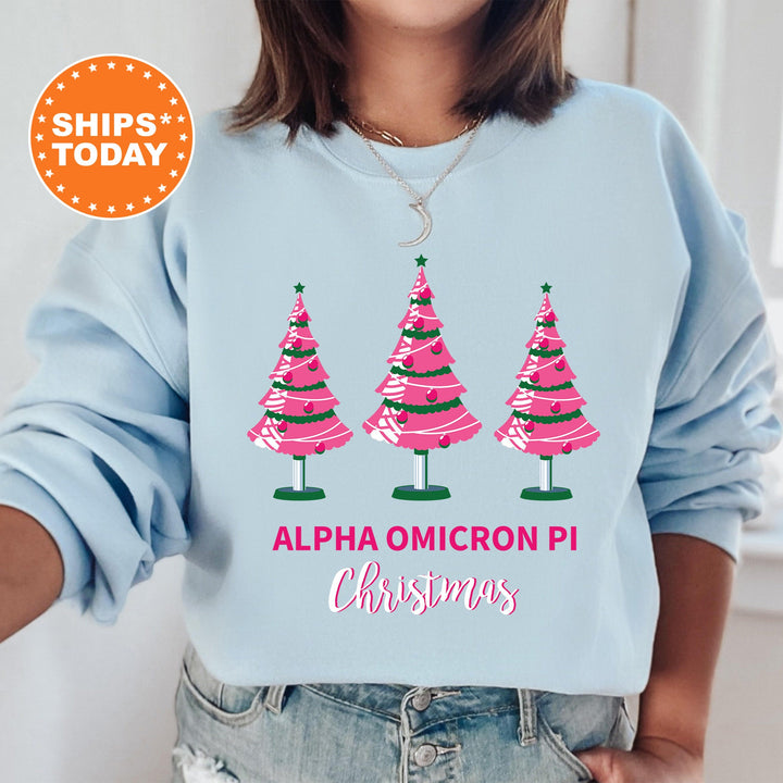 a woman wearing a blue sweatshirt with pink christmas trees on it
