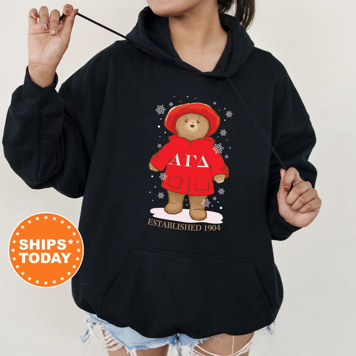 a woman wearing a black hoodie with a teddy bear on it