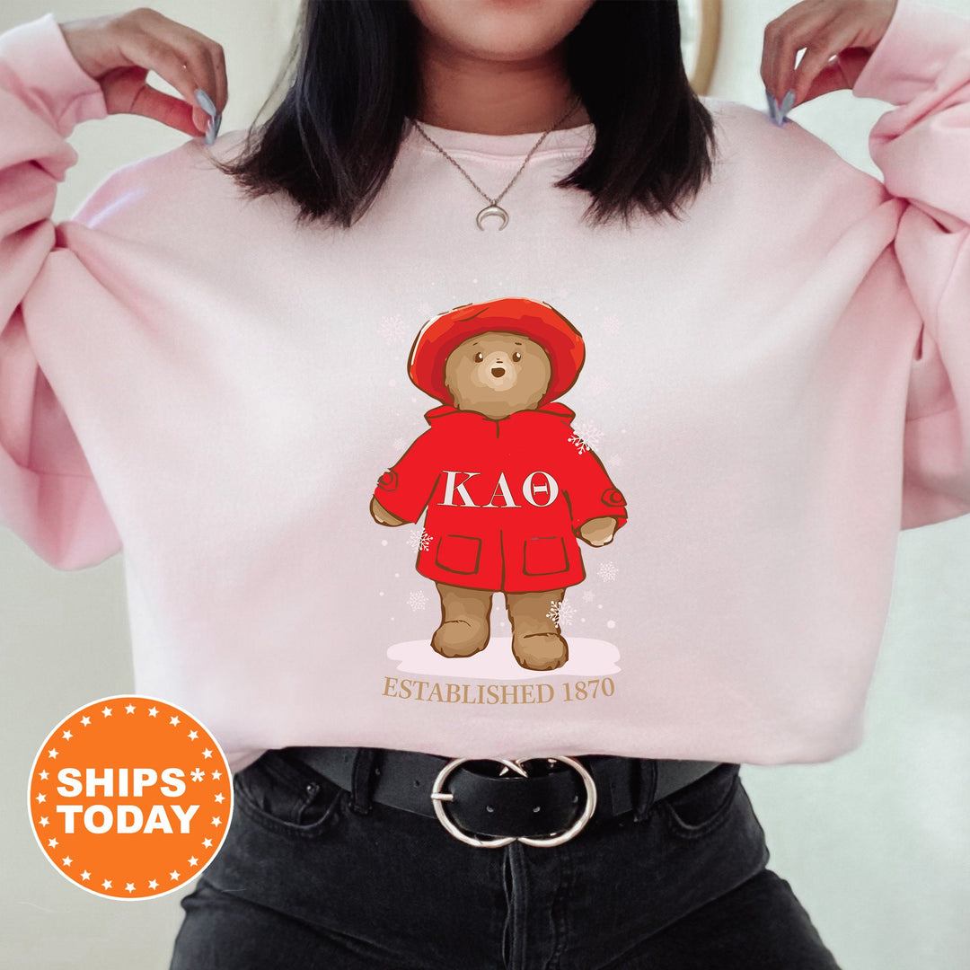 a woman wearing a pink sweatshirt with a teddy bear on it