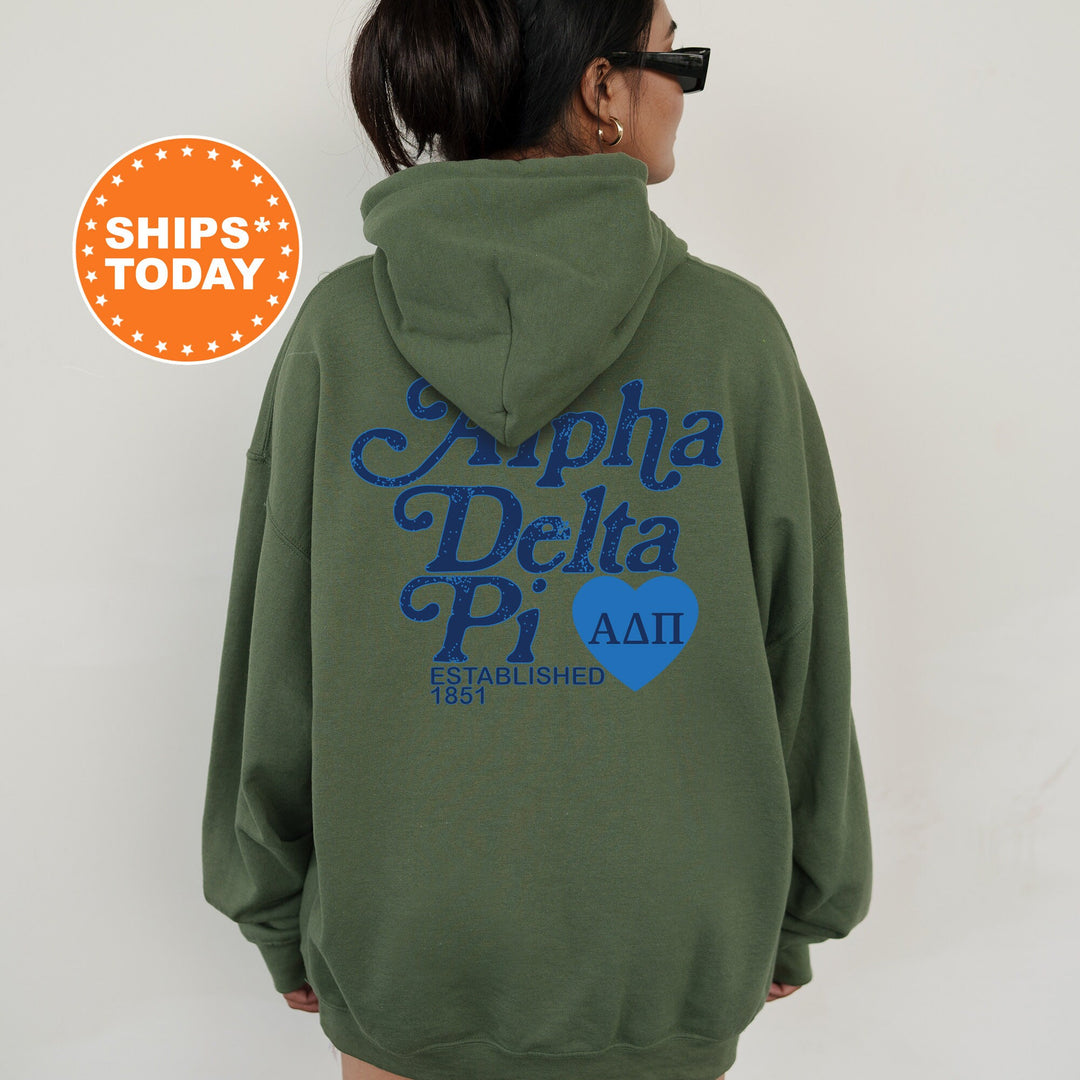 a woman wearing a green hoodie with the words alpha delta pi on it