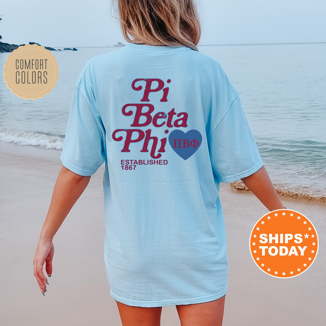 a woman walking on the beach wearing a pi beta phi shirt