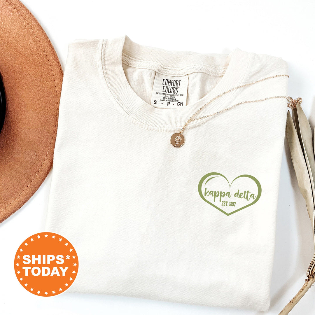 a white shirt with a green heart and a brown hat