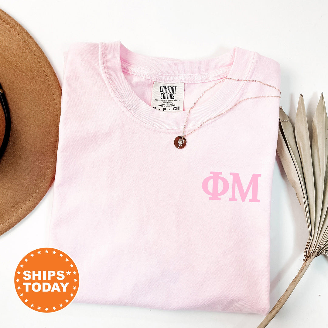 a hat, sunglasses, and a pink shirt on a white surface