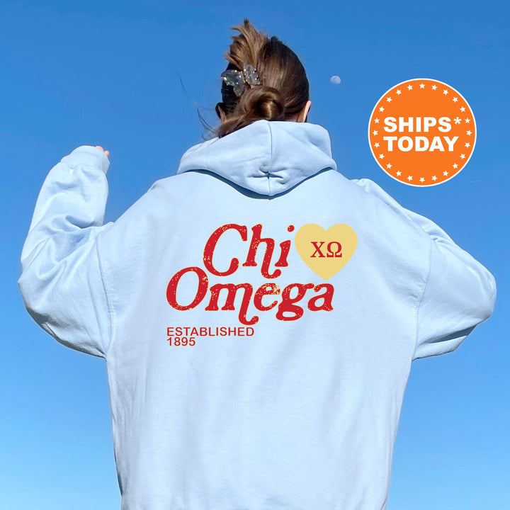 a woman wearing a white hoodie with the words chi omega on it