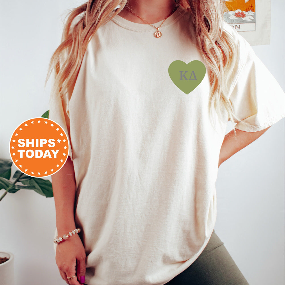 a woman wearing a white shirt with a green heart on it